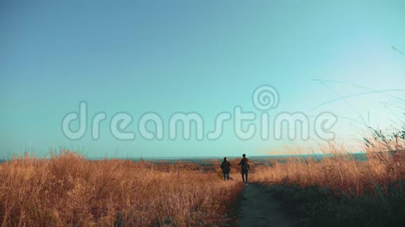两个带着生活方式背包徒步旅行的男子正在沿着爬山的小径散步慢动作视频的预览图