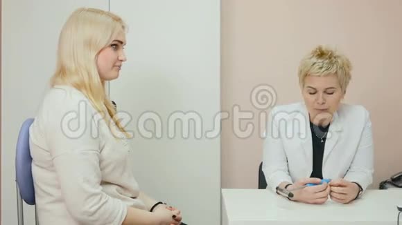 一位女士和一位医生坐在诊所里视频的预览图