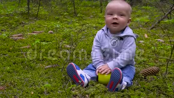 婴儿是婴儿坐在森林里吃大苹果视频的预览图