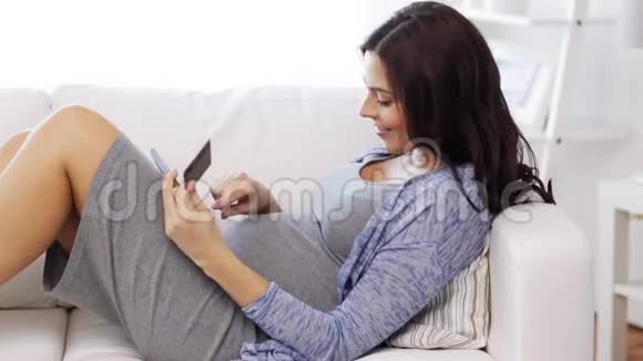 有平板电脑和信用卡的孕妇视频的预览图