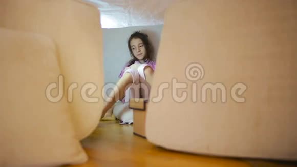 一个小女孩坐在一个临时的枕头屋和一个毯子屋里视频的预览图