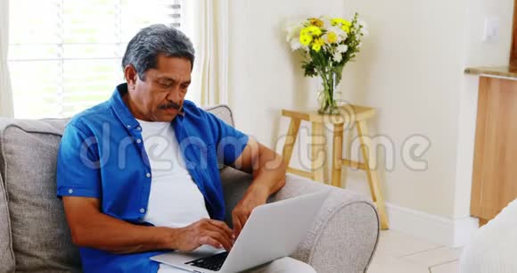 4k客厅里的老人用笔记本电脑视频的预览图