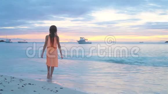 可爱的快乐小女孩在白色海滩日落视频的预览图