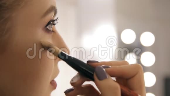 专业的化妆师和发型师为一个美丽的年轻女孩创造了一个美丽的形象视频的预览图