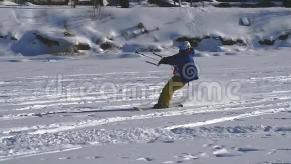 慢动作一名男运动员在滑雪板上表演Kiting他在一个大湖的冰上翻滚滚动他表演视频的预览图