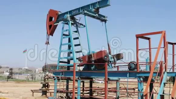 阿塞拜疆巴库一个油田的油泵蓝天背景下的油泵工作剪影视频的预览图