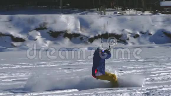 慢动作一名男性运动员在滑雪板上进行扭打他在一个大湖的冰上翻滚滚动他表演视频的预览图