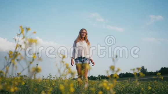 美丽的微笑女孩在春天的田野上草甸笑着快乐的年轻女模特健康长寿的肖像视频的预览图