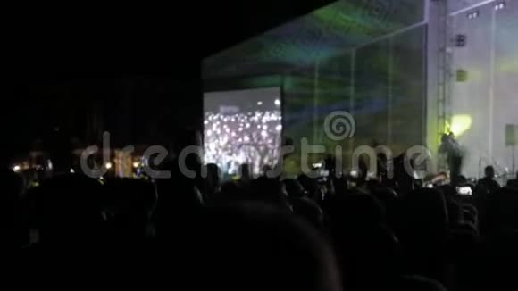 音乐音乐会上的人群在明亮的生活方式丰富多彩的面前成群结队的人在智能手机上拍照视频的预览图