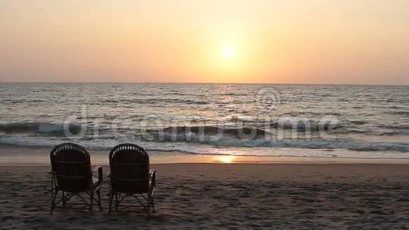 日落时分两张靠近海岸线的椅子视频的预览图