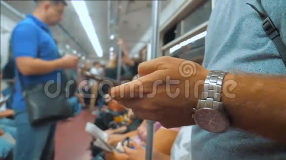 休闲男子从手机智能手机屏幕上阅读同时看着地铁里的领航员视频的预览图