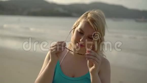 海滩上的金发女郎戴着太阳镜视频的预览图