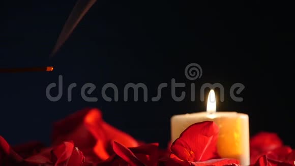 在黑暗的背景上燃烧着香枝和蜡烛在熏香和烛光中燃烧着视频的预览图
