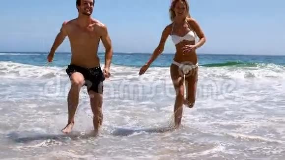 一对跳在海滩上的夫妇视频的预览图