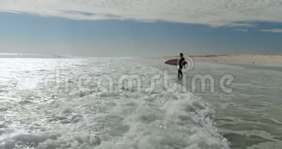 带着冲浪板在海上行走的女人视频的预览图