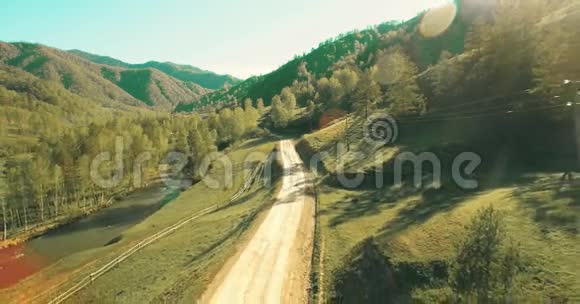 空中UHD4K视野低空飞越山区乡村土路和草地视频的预览图