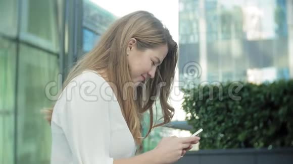 年轻女商人在城市公园商务中心使用智能手机视频的预览图