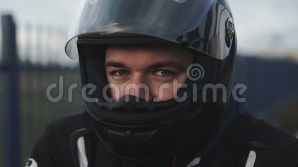 年轻迷人的摩托车手带着黑色头盔在街上骑摩托车的人视频的预览图