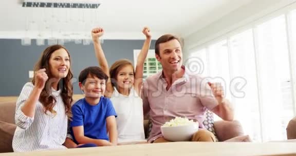 幸福的家庭在客厅看电视视频的预览图