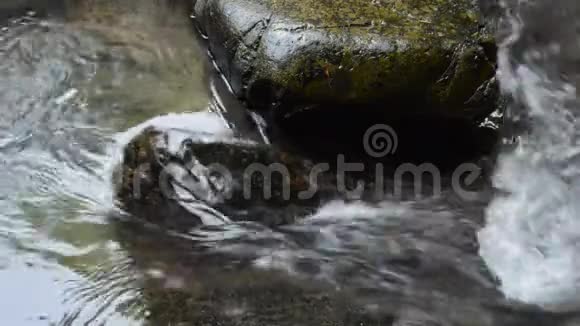 水落在河上穿过岩石和石头视频的预览图