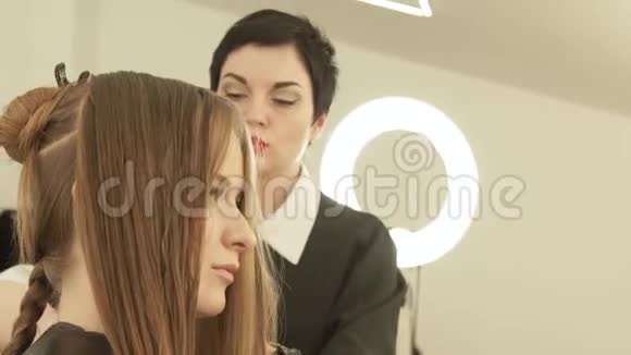 美容师在美容院理发时梳理女性头发关闭理发师在视频的预览图