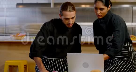 男性和女性高管讨论笔记本电脑4k视频的预览图