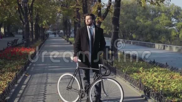 年轻的商人骑着自行车站在城市小巷里视频的预览图