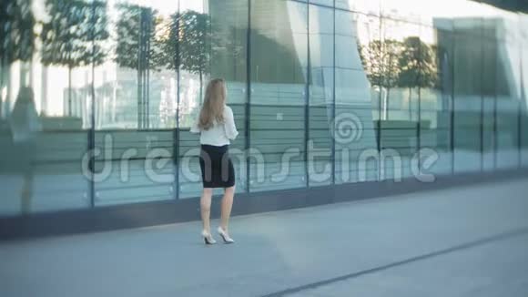 年轻的商务女性正漫步在城市公园商务中心视频的预览图