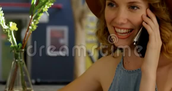 微笑的女人在4K4k的咖啡馆打电话视频的预览图
