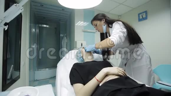 美容师制作注射塑料嘴唇在诊所隆唇的年轻女子视频的预览图