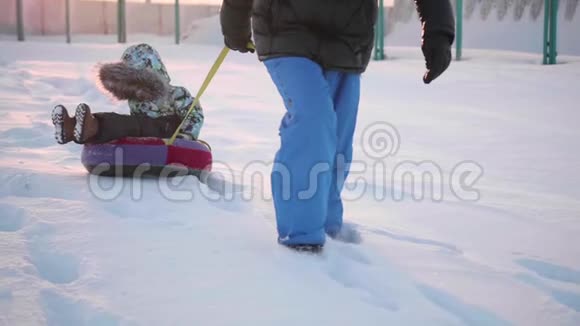 一个快乐的孩子在雪管里骑着雪慢动作冬天的雪景户外运动视频的预览图