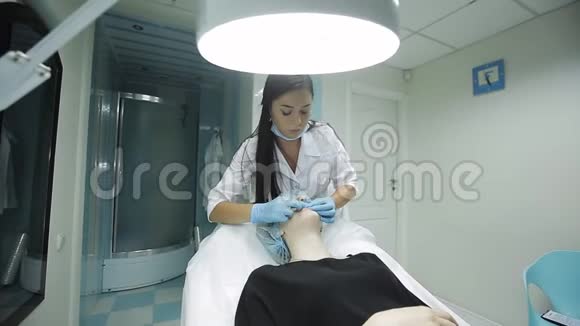 美容师制作注射塑料嘴唇在诊所隆唇的年轻女子视频的预览图