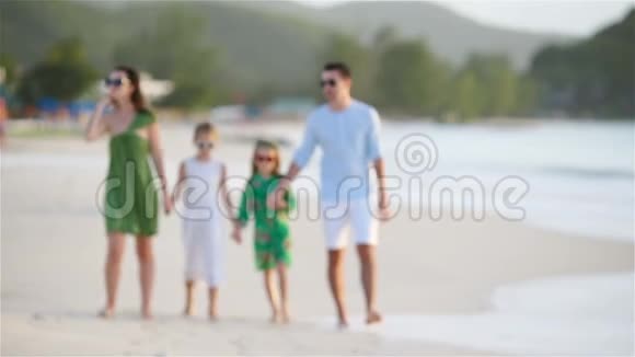 一家四口在白色海滩散步视频的预览图
