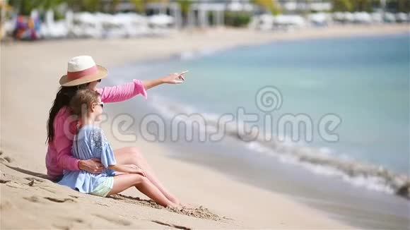 白色海滩上的小女孩和年轻母亲视频的预览图