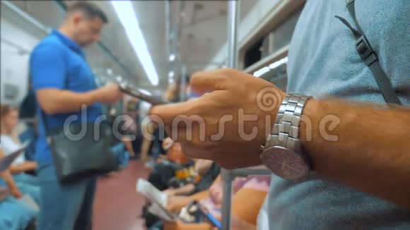 休闲男子从手机智能手机屏幕上阅读同时看着地铁里的领航员视频的预览图