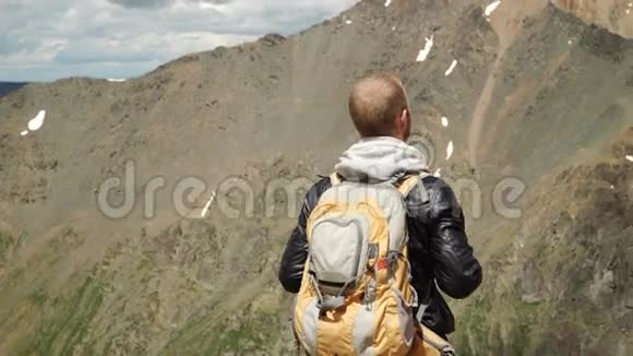 徒步旅行者背着背包站在山顶上视频的预览图