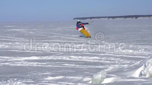 慢动作一名男性运动员在滑雪板上进行扭打他在一个大湖的冰上翻滚滚动他表演视频的预览图