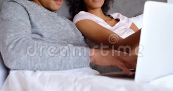 在卧室4k的床上使用笔记本电脑的情侣视频的预览图