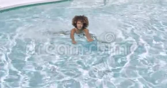 快乐的女人在游泳池游泳视频的预览图