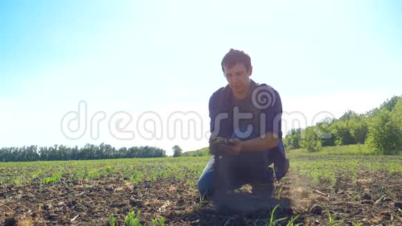 一个农民工人手里握着新鲜的土壤慢动作视频人的地面泥土保持泥土春天的象征视频的预览图