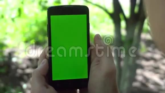 特写男性手触摸智能手机绿色屏幕Chroma键快关门跟踪运动视频的预览图