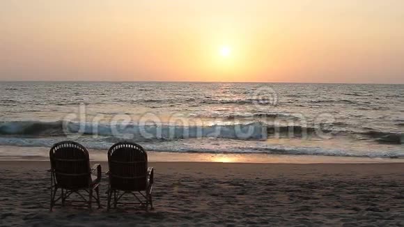 日落时两把椅子靠近海岸线视频的预览图