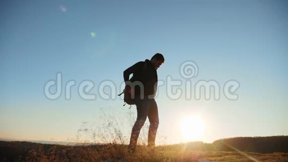 人走旅游徒步探险登山者日落爬山慢动作视频徒步旅行者的阳光在顶部获胜视频的预览图