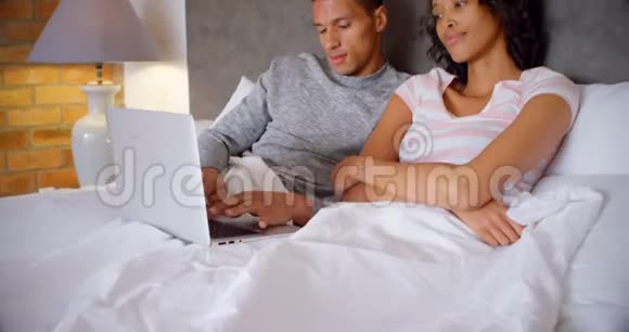 在卧室4k的床上使用笔记本电脑的情侣视频的预览图