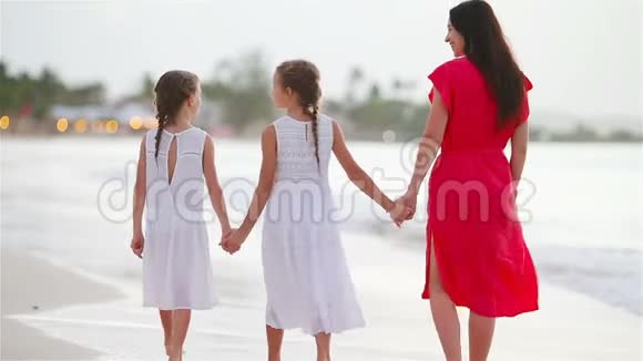 可爱的小女孩和年轻的母亲在白沙滩视频的预览图
