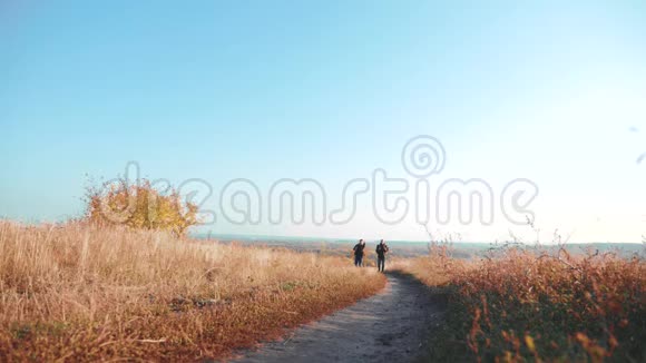 两个背着背包徒步旅行的人正沿着小路爬山慢速视频视频的预览图