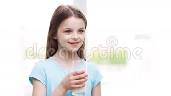 快乐的微笑小女孩在家喝牛奶视频的预览图