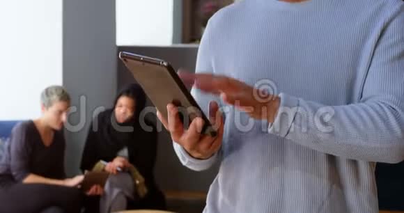 男性高管使用数码平板电脑办公4k视频的预览图