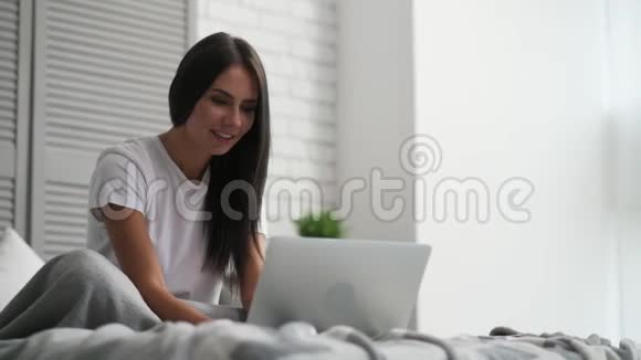 开朗的女人在家里用笔记本电脑视频的预览图
