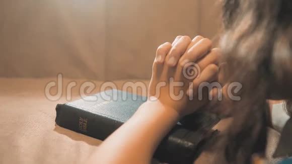 小女孩在夜里祈祷小女孩用手祈祷小女孩神圣的生活方式圣经在她的圣经中祈祷视频的预览图
